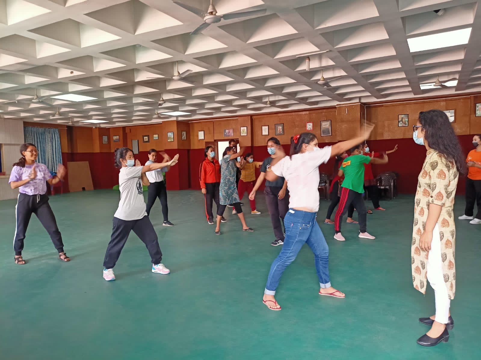 Several women practicing self-defense in a big hall.